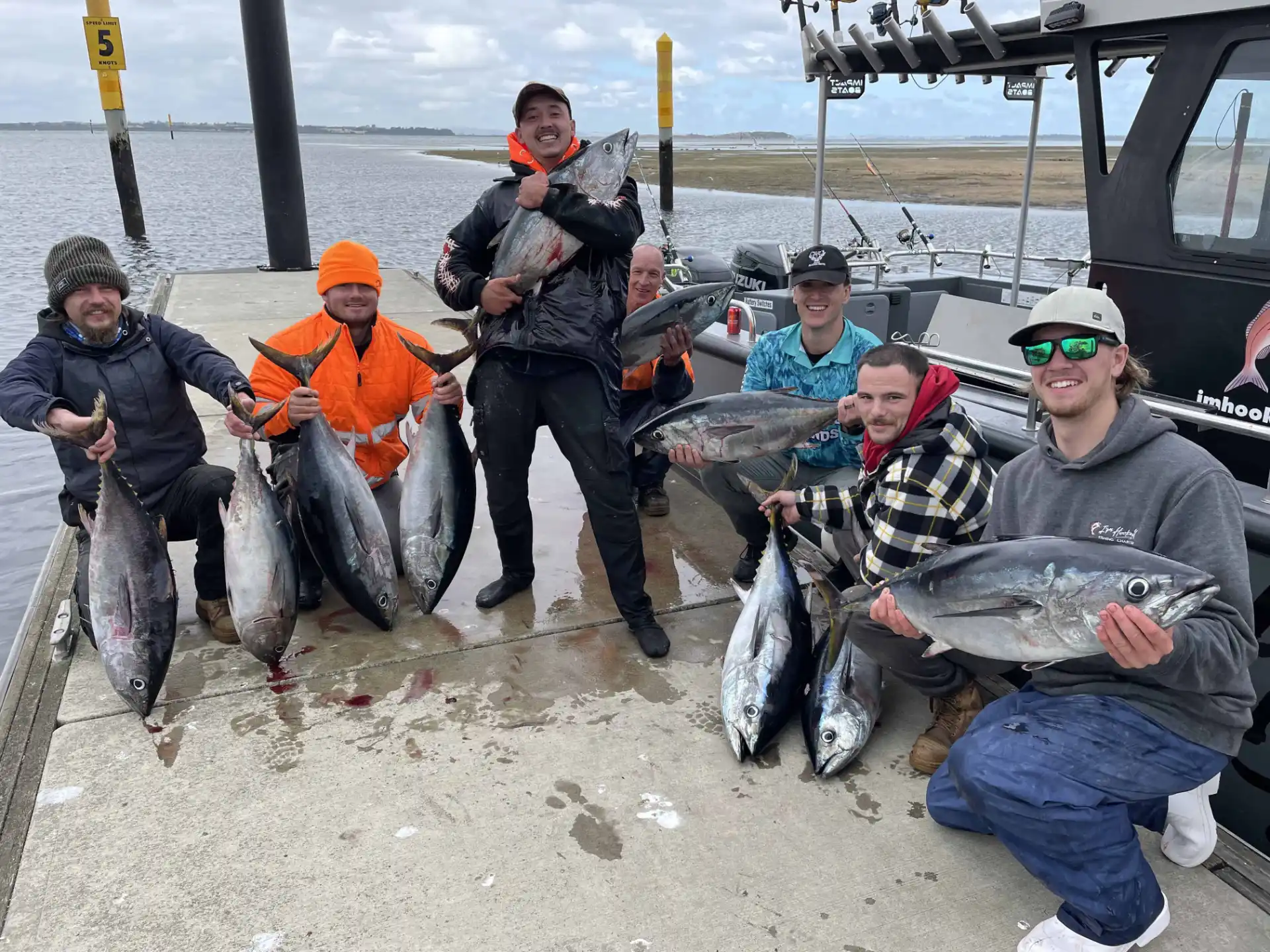 A group on the jetty with their tuna catch