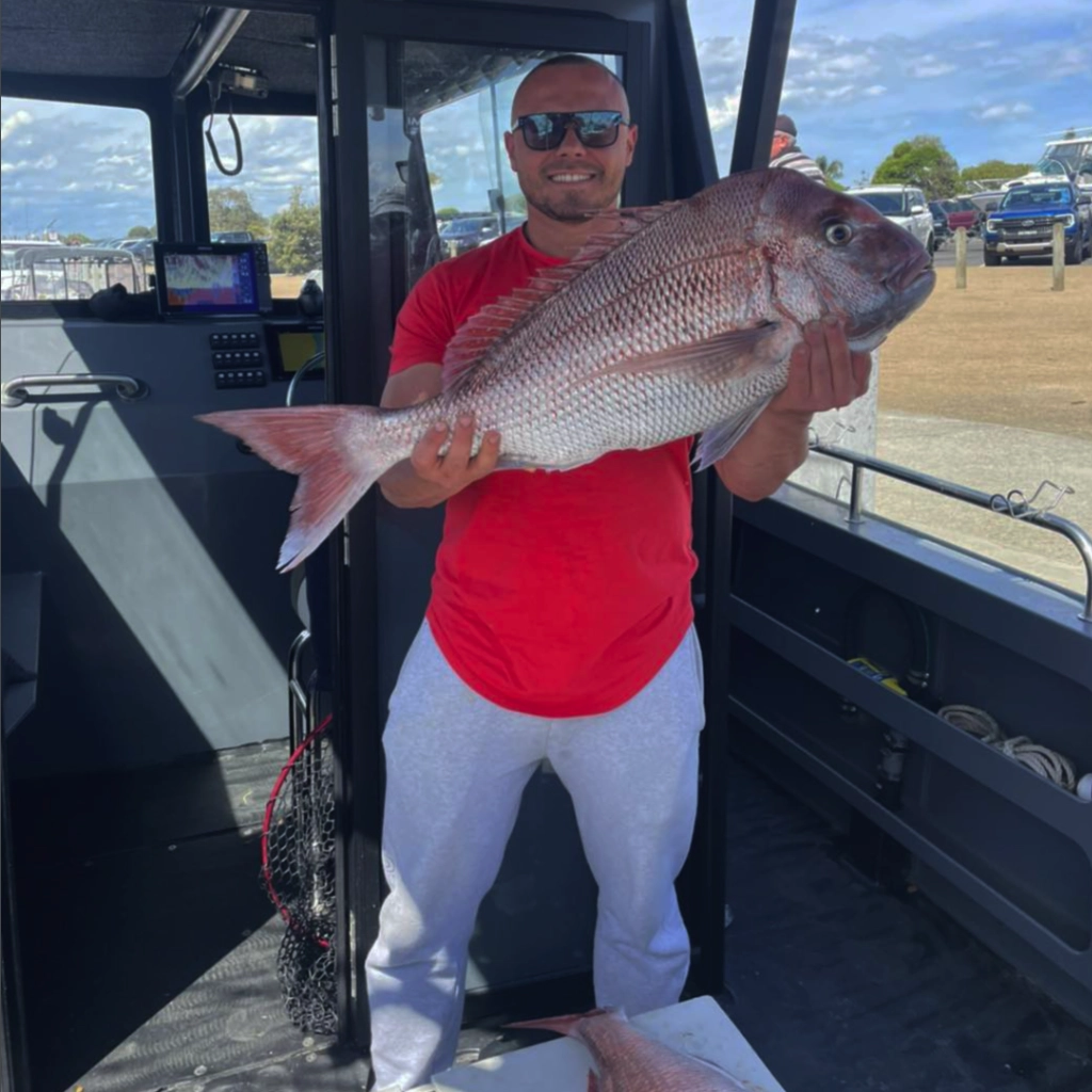 An angler with a big Snapper on the boat
